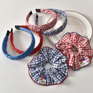 Conjunto de gomas y diademas de cuadros rojos y azules en una bandeja de cerámica blanca