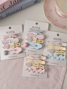 Close-up of four pastel macaron hair clips with heart and wave patterns on display card