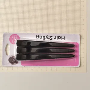 Detailed view of 12cm professional hair clips set on a measurement grid for scale