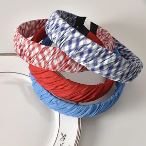 Primer plano de diademas plisadas en tela de cuadros rojos y azules con textura