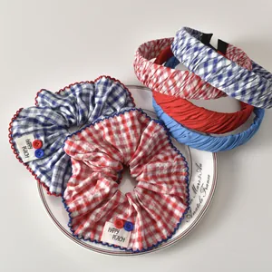 Set de gomas y diademas de cuadros rojos y azules con etiquetas de Happy Peach en bandeja