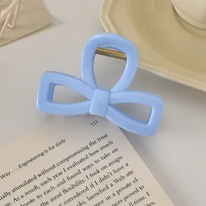 Détail macro d'une pince à cheveux nœud bleu clair sur un fond crème élégant
