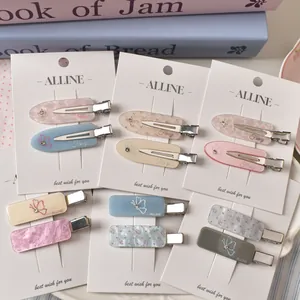 Detail showing acrylic hair clips with butterfly patterns and rhinestones on cards