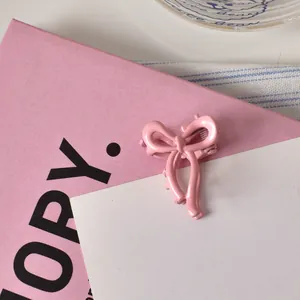Dettaglio di un fermaglio per capelli a fiocco rosa su uno sfondo decorativo elegante