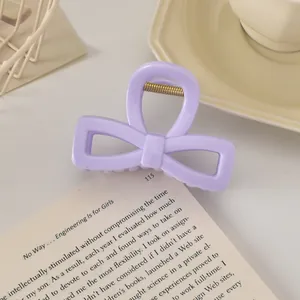 Détail d'une pince à cheveux nœud lavande avec ressort en métal sur un livre