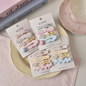 Close-up of pastel floral and plaid hair clips set arranged on a decorative plate