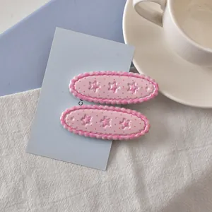 Détail de barrettes roses à pois avec étoiles et bords ondulés sur tissu doux