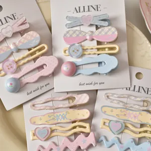 Pastel checkered floral hair clips set with heart and bow designs on display card