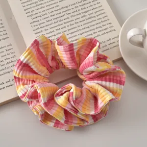Close-up of colorful striped scrunchie on a book with aesthetic lifestyle props
