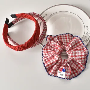 Detalle de un conjunto de coleteros y diademas a cuadros rojos y azules con botones