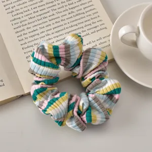 Detailed view of colorful striped scrunchie texture with knitted fabric on a book