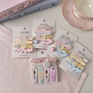 Pastel macaron floral hair clip set with wavy checkered bow and heart shapes on display card