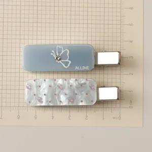 Detail view of acrylic hair clips with blue butterfly motifs and pink polka dot patterns