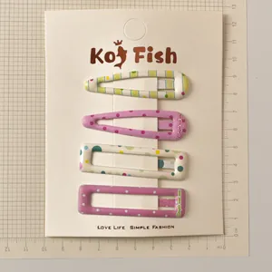 Close-up of 4-piece colorful polka dot and striped metal hair clips on a display card