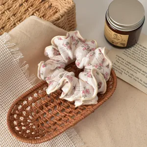 Floral scrunchie with red flowers on cream fabric in a woven basket display