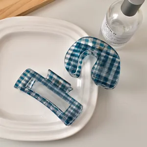 Blau-weiß kariertes Haarklammern-Set auf weißem Keramiktablett mit glänzendem Finish