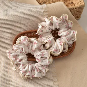 Close-up of floral scrunchies with pink flower patterns on beige fabric in a woven basket