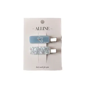 Acrylic polka dot and butterfly print hair clips set on display card in blue and white