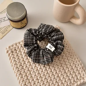 Détail d'un chouchou à motif pied-de-poule noir et blanc sur un bureau décoratif