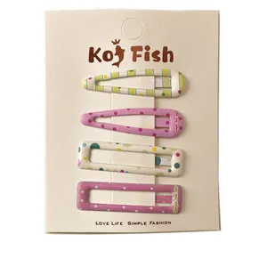 Set of four colorful polka dot and striped hair clips on display card for women and kids