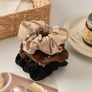 Three-piece faux leather scrunchies with pearls in beige, brown, and black