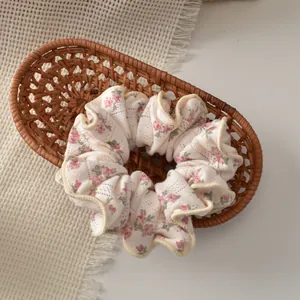 Close-up of floral knitted scrunchie with pink blossoms in a rustic woven basket