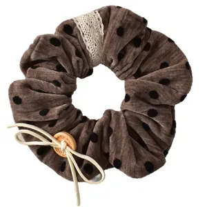 Brown velvet polka dot scrunchie with lace trim and decorative wooden button detail