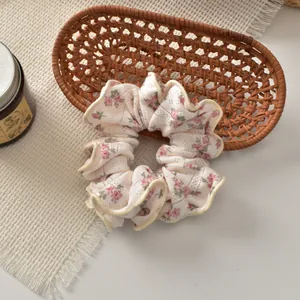 Chic floral scrunchie hair tie with pink flower pattern on a cream fabric background