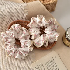 Floral print scrunchie set with pink blossoms and ruffled edges on vintage books