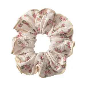 Floral print scrunchie in beige fabric with pink rose patterns for hair styling