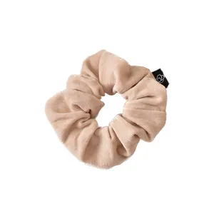Elegant beige velvet scrunchie with soft pleats and a floral brand tag for women