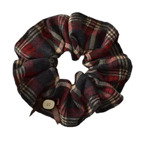 Retro plaid scrunchie with red black check pattern and decorative bow button detail