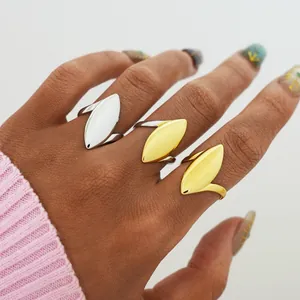 Macro detail of three gold and silver marquise-shaped rings on hand with high gloss finish