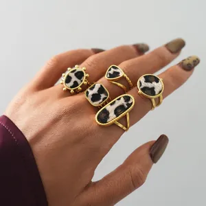 Detail of five gold rings featuring mixed leopard and cow print faux horsehair textures