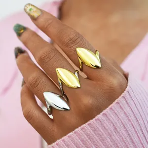 Close-up of elegant gold and silver oval geometric rings styled on a model hand