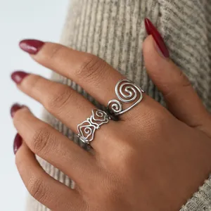 Elegant stainless steel silver swirl rings with vintage filigree patterns on model hands