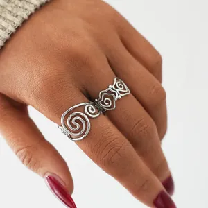Macro detail of silver hollow spiral ring featuring intricate rose floral craftsmanship