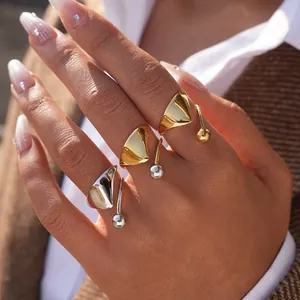Anillo geométrico triangular irregular con una delicada perla de metal suspendida
