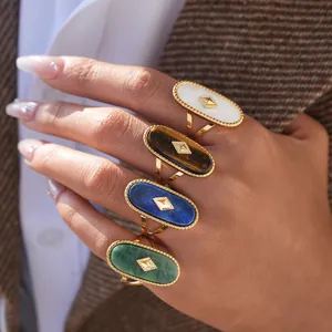 Detailed macro view of four vintage gold rings with oval stone inlays on hands
