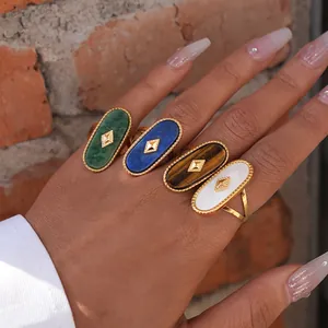 Set of four gold stainless steel rings with oval gemstones shown on a model's hand