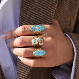 Vintage gold stainless steel rings set with natural turquoise stones on model's hand