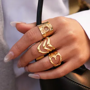 Set de tres anillos dorados de acero inoxidable con motivos de corazón y sol