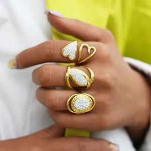 Detailed view of three gold titanium rings featuring heart and oval zircon designs