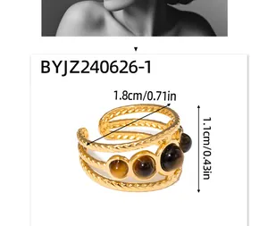 Detailed view of gold triple-layered ring with brown tiger eye natural stone insets
