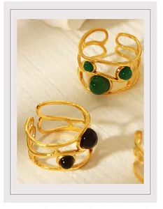 Detail of 18K gold-plated open rings with green and black stones in a unique silhouette