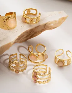 Detailansicht goldener Boho-Edelstahlringe mit rosa Natursteinen und Hammerschlagoptik