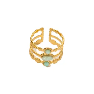 Detail eines vintage 18K vergoldeten Edelstahlrings mit drei grünen Steinen und Wellenstruktur