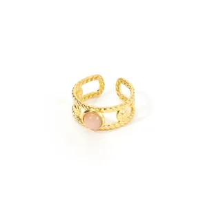 Detailed macro view of a gold braided open ring with a round pink stone cabochon