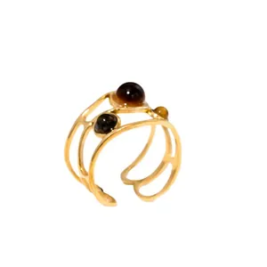 Detail view of gold-plated open ring with three brown natural stones in cutout design