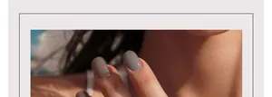 Detailopname van elegante grijspaarse glanzende nagellak op een hand bij de hals